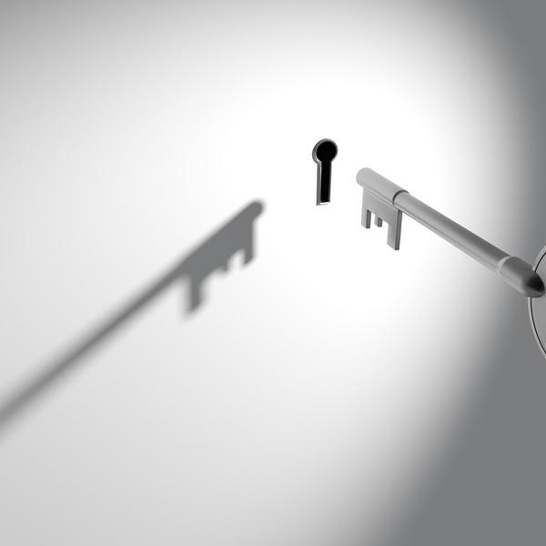 Old fashioned key hovering in front of key hole 