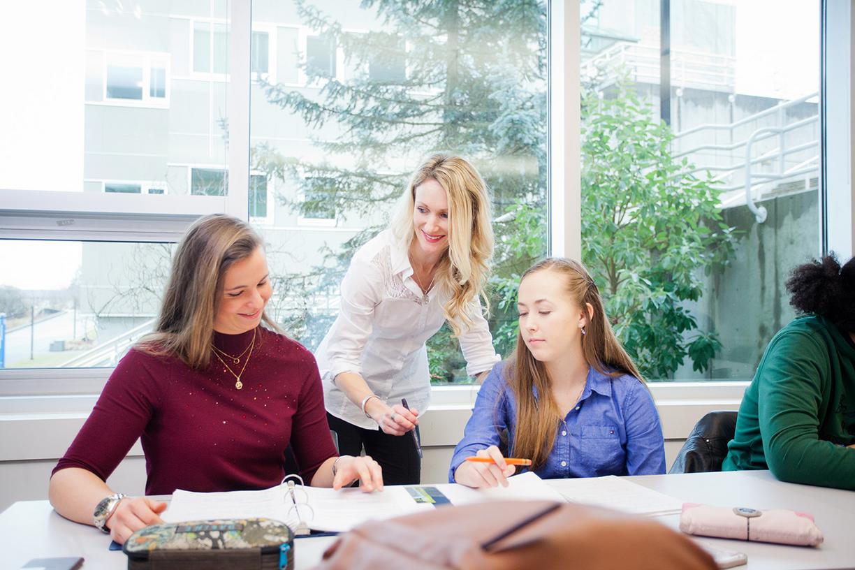 female instructor stands with two seated females